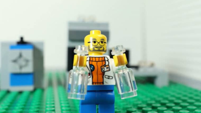 a lego character scientist holding two beakers